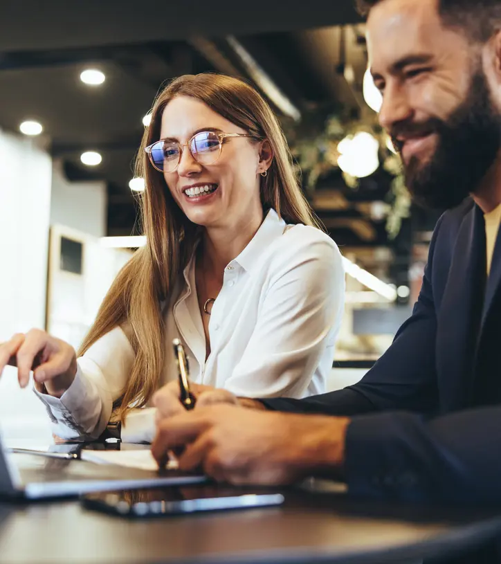 Kvinna och man med laptop i ett kontorslandskap.