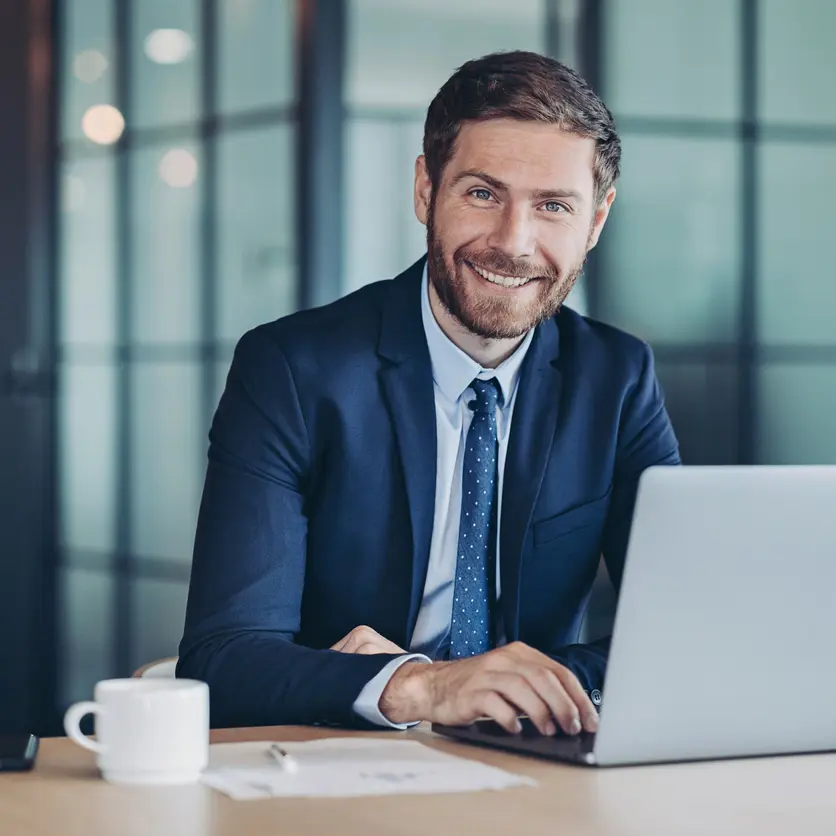 Man med dator tittar in i kameran